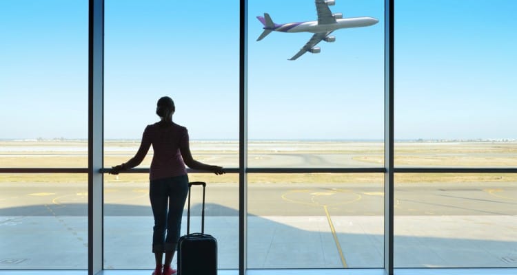 woman-watching-plane-airport-750x400